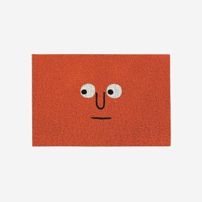 Morsom rød dørmatte med tegneserieansikt