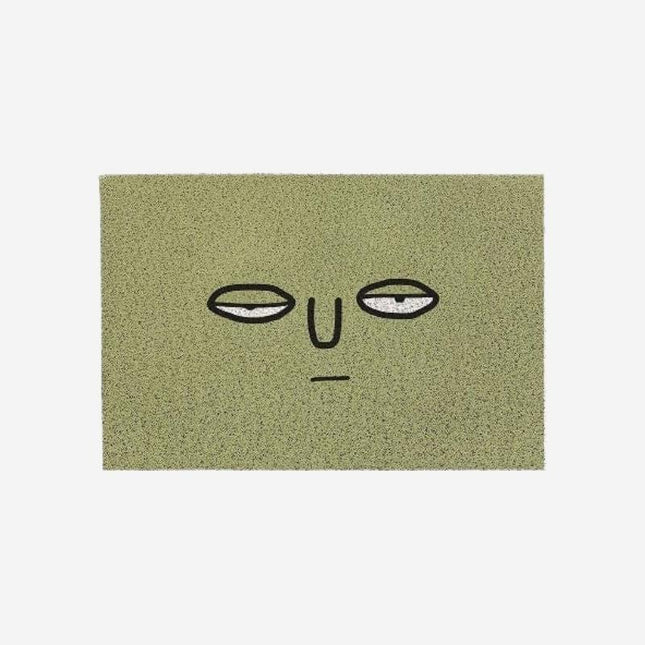 Morsom grønn dørmatte med trøtt ansikt