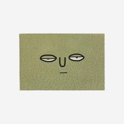 Morsom grønn dørmatte med trøtt ansikt