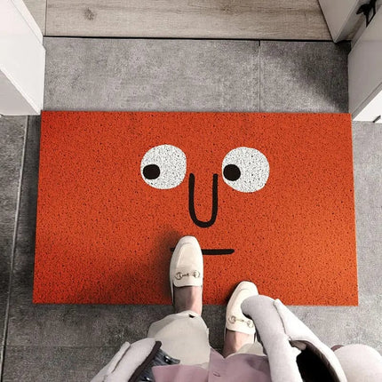 Morsom rød dørmatte med tegneserieansikt