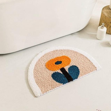 Halvrund badematte med oransje blomst