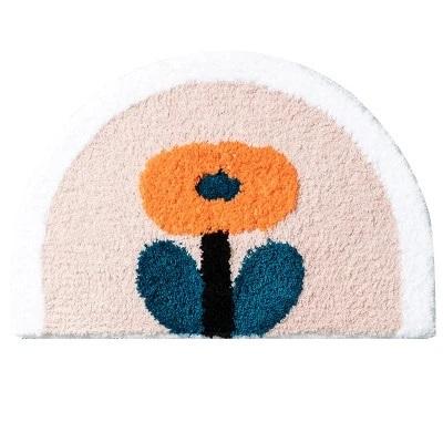 Halvrund badematte med oransje blomst