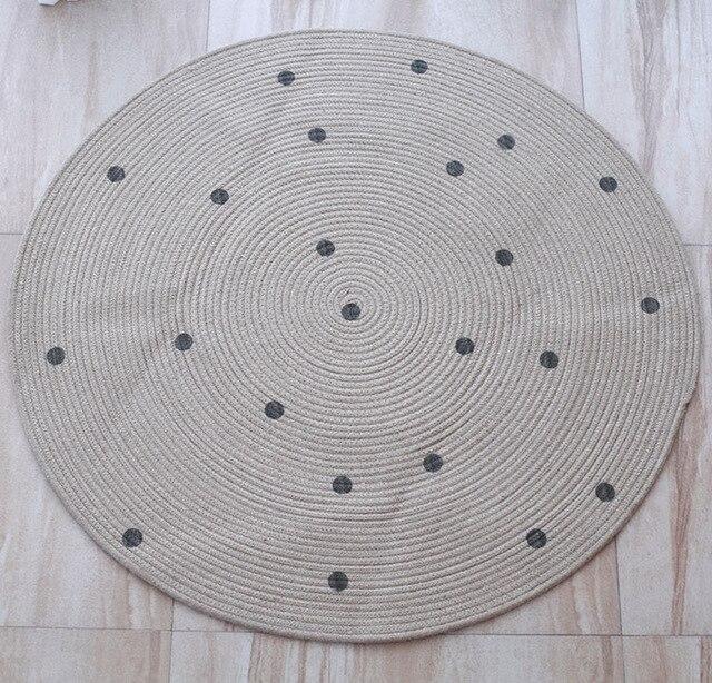 Rundt juteteppe med sorte prikker